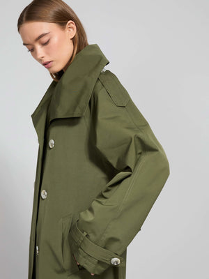 A model showcases a stylish olive green trench coat with a high collar and large buttons, embodying MEOTINE's modern aesthetic.