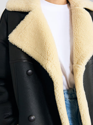 Cozy black and cream MEOTINE jacket featuring a plush collar, paired with a simple white tee and denim bottoms.