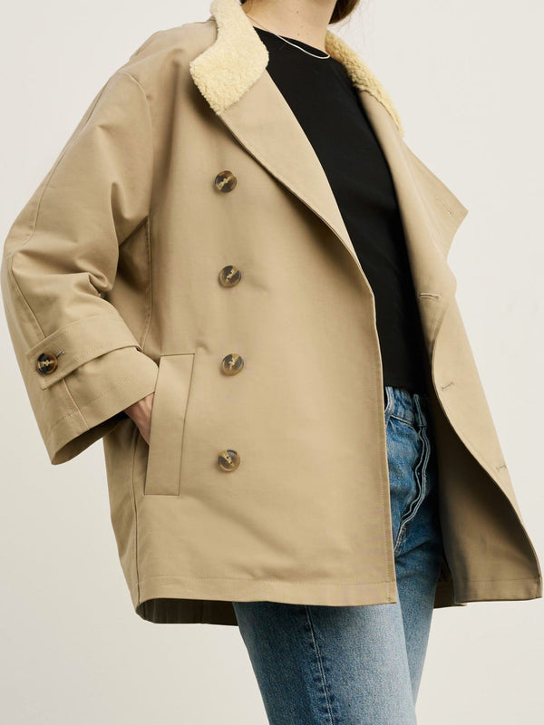 A stylish beige coat with a soft collar, paired with a black top and blue jeans, showcasing MEOTINE's chic design.