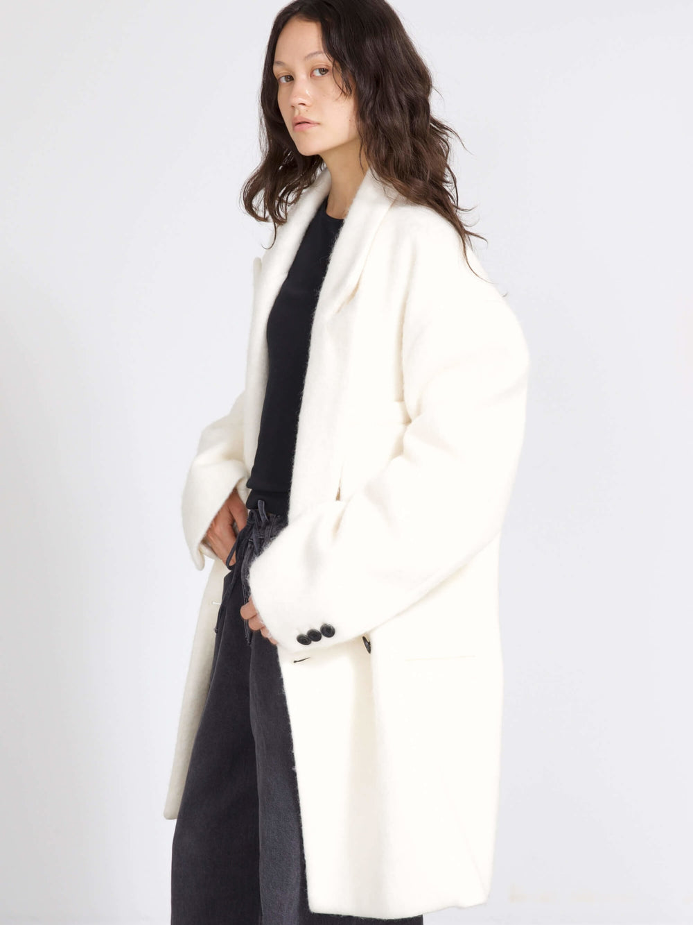 A model wearing a cozy white oversized coat paired with wide-leg dark jeans, showcasing MEOTINE's stylish winter collection.