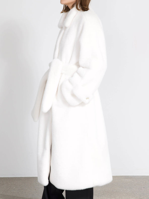A model showcases a luxurious white MEOTINE coat with a belted waist and soft, fluffy texture, perfect for winter elegance.