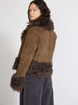 A model showcases a brown suede jacket with a fluffy fur collar and cuffs, embodying MEOTINE's stylish and cozy aesthetic.