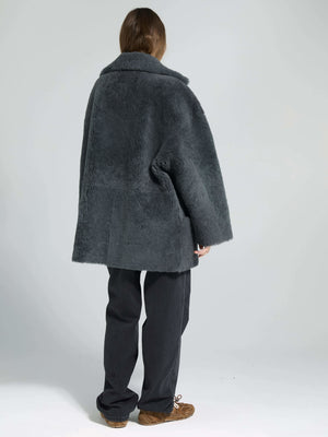 Cozy gray oversized coat with a plush texture, styled with loose black trousers, perfect for a chic winter look by MEOTINE.
