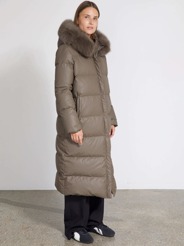 A model showcases a long, olive green puffer coat with a fur-lined hood, embodying MEOTINE's stylish winter warmth.