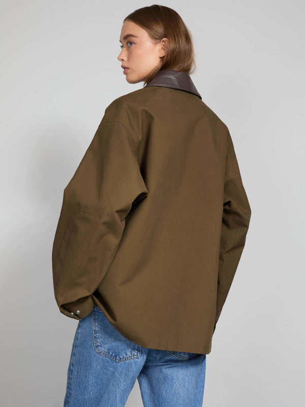 Oversized brown shirt with a contrasting collar, styled with blue jeans, showcasing a modern look by MEOTINE.