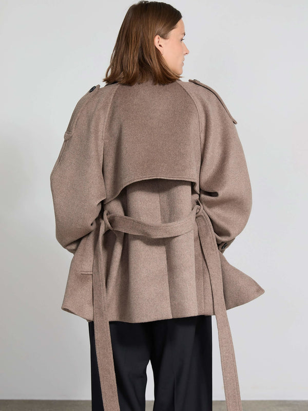 A model showcases a stylish brown oversized coat with a unique layered design and a belted waist, perfect for a chic look by MEOTINE.