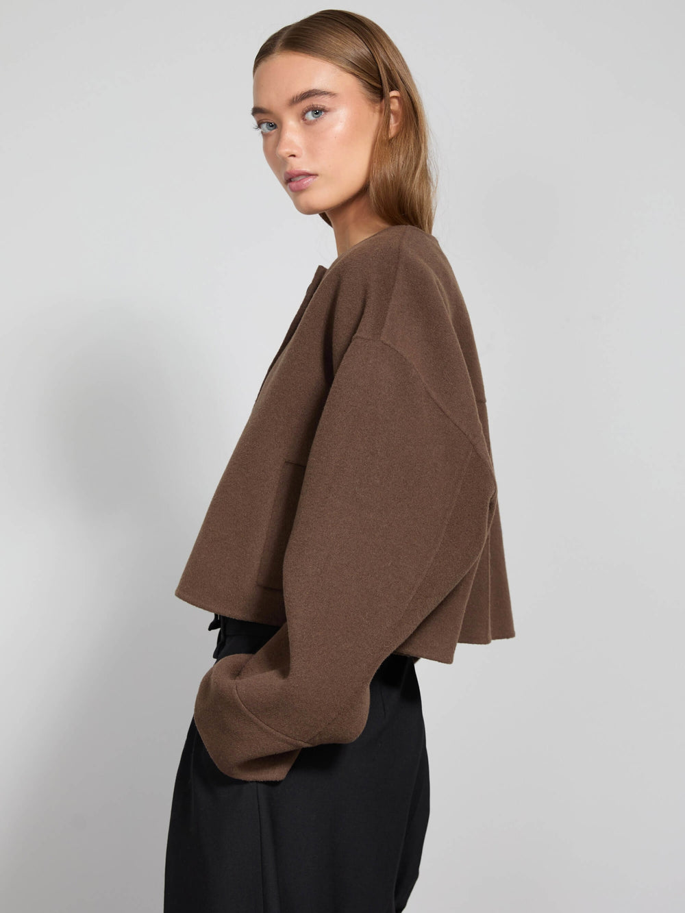Brown cropped jacket with a round neckline and large buttons, styled with relaxed sleeves, perfect for a chic look by MEOTINE.