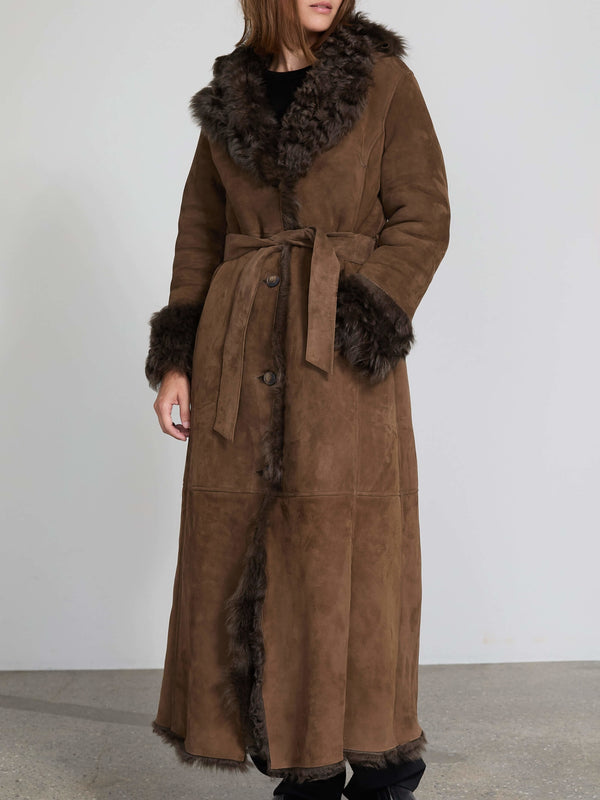Long brown coat with a fur collar and cuffs, featuring a tie waist, perfect for stylish warmth. By MEOTINE.