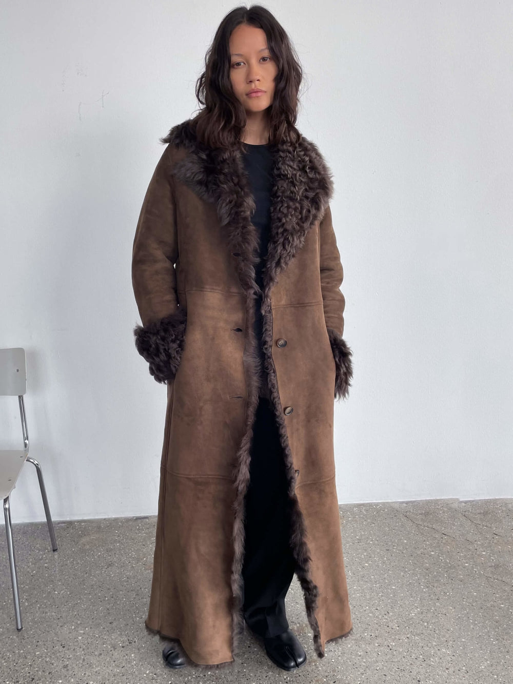 A model showcases a stylish brown coat with a fur collar and cuffs, embodying MEOTINE's chic and cozy aesthetic.