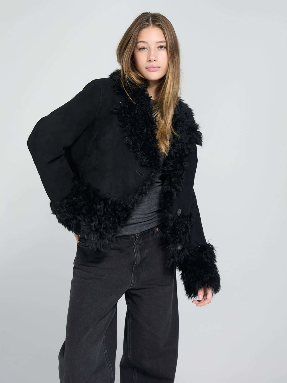 Stylish black jacket with fluffy fur trim and a button closure, perfect for a chic look. Designed by MEOTINE.