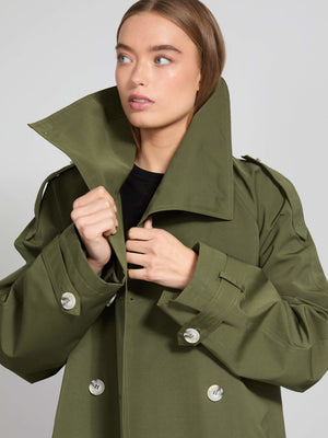 A model wearing a stylish olive green oversized trench coat with a high collar, showcasing MEOTINE's modern design.