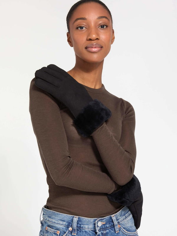Stylish black gloves with a plush fur cuff, worn by a model in a fitted top, showcasing MEOTINE's elegant winter accessory.