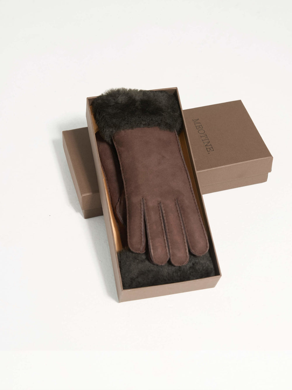 Brown suede gloves with a soft dark fur cuff, perfect for winter warmth and style. Ideal accessory by MEOTINE.