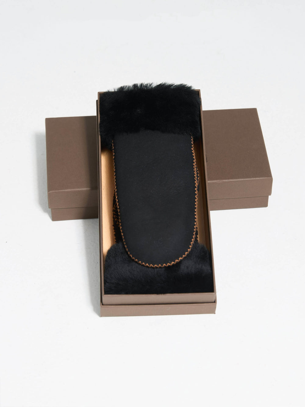 Black mittens with a soft faux fur cuff and stitching detail, perfect for warmth and style. Ideal for winter wear by MEOTINE.