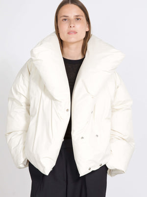 A model wears a stylish oversized white puffer jacket with a dramatic collar, showcasing MEOTINE's modern design.
