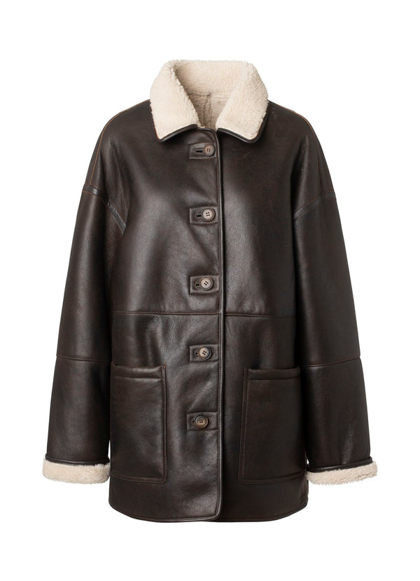 Brown leather jacket with a cozy shearling collar and front pockets, perfect for stylish warmth. MEOTINE offers timeless elegance.