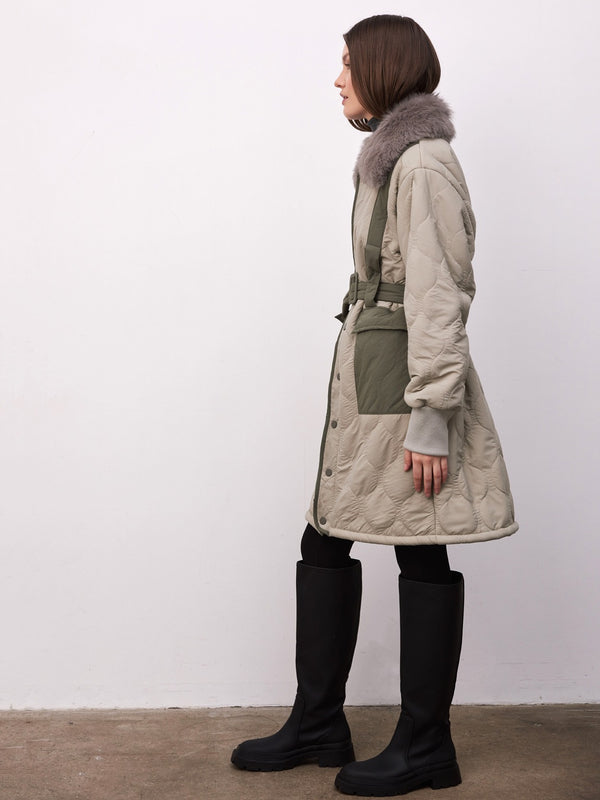 Stylish MEOTINE quilted coat with a fur collar, featuring a belted waist and contrasting green patches, perfect for winter fashion.