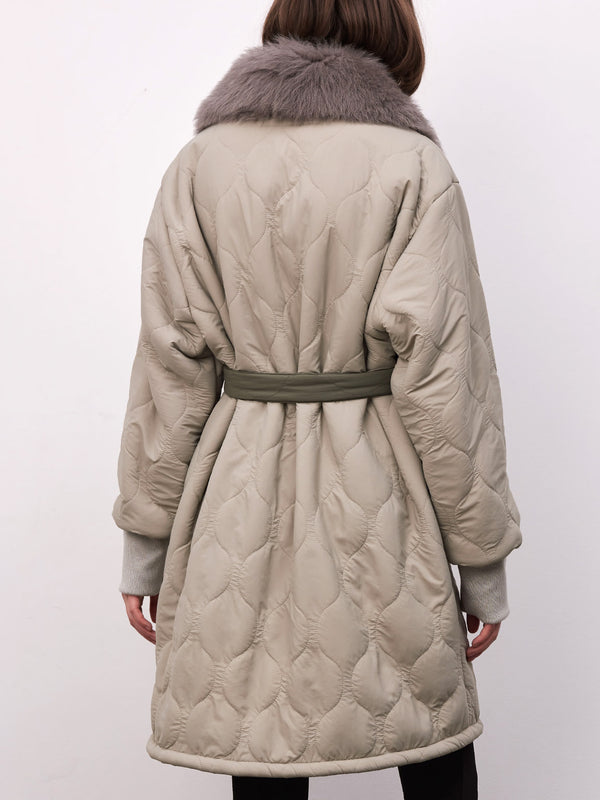 A stylish quilted coat with a plush fur collar and a belted waist, showcasing a modern and cozy design by MEOTINE.