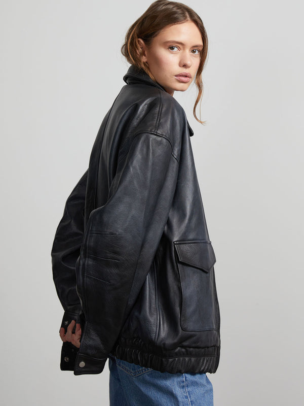 A model showcases a stylish black leather jacket with a relaxed fit and elastic hem, embodying MEOTINE's modern aesthetic.