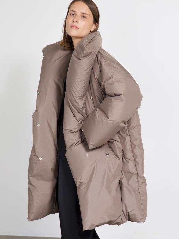 A model wearing a stylish oversized brown puffer coat by MEOTINE, showcasing a modern and cozy winter look.