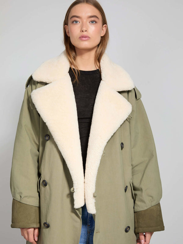 A model showcases a stylish olive green coat with a plush white collar, embodying MEOTINE's chic and cozy aesthetic.