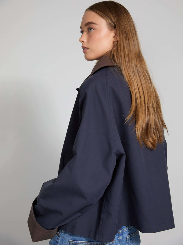 A model showcases a stylish navy blue oversized jacket with a relaxed fit, paired with casual denim, by MEOTINE.