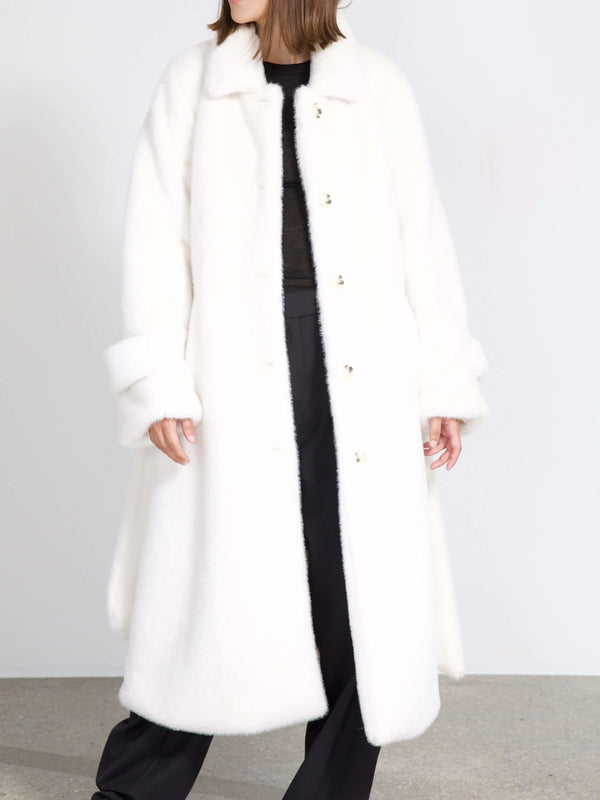 A model wears a cozy, oversized white coat with a soft texture and button closure, showcasing MEOTINE's stylish winter fashion.