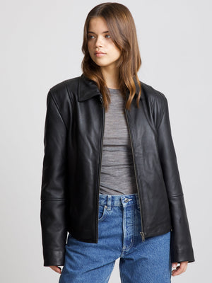 Stylish black leather jacket with a modern cut, paired with a gray top and blue jeans, showcasing MEOTINE's chic design.
