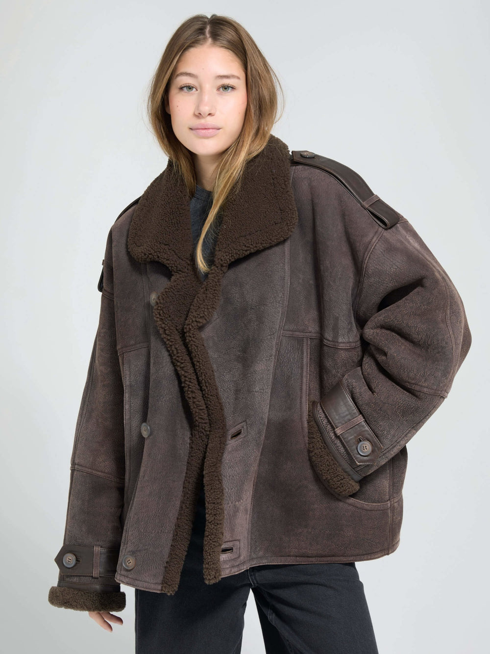 A model wears a cozy, oversized brown shearling jacket with a plush collar, showcasing MEOTINE's stylish winter outerwear.