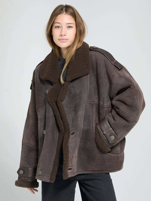 A model wears a cozy, oversized brown shearling jacket with a plush collar, showcasing MEOTINE's stylish winter outerwear.