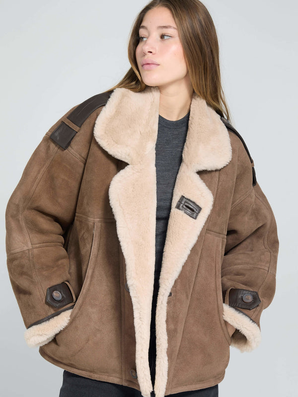 Cozy brown shearling jacket with a plush collar and leather accents, perfect for stylish warmth this season by MEOTINE.