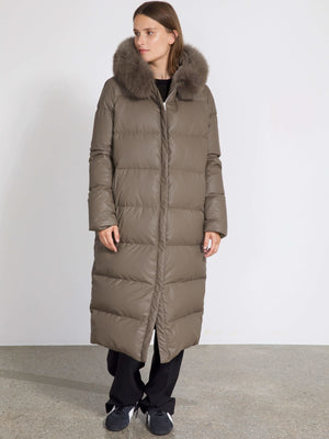 A woman models a long, olive green puffer coat with a fur-lined hood, showcasing MEOTINE's stylish winter outerwear.