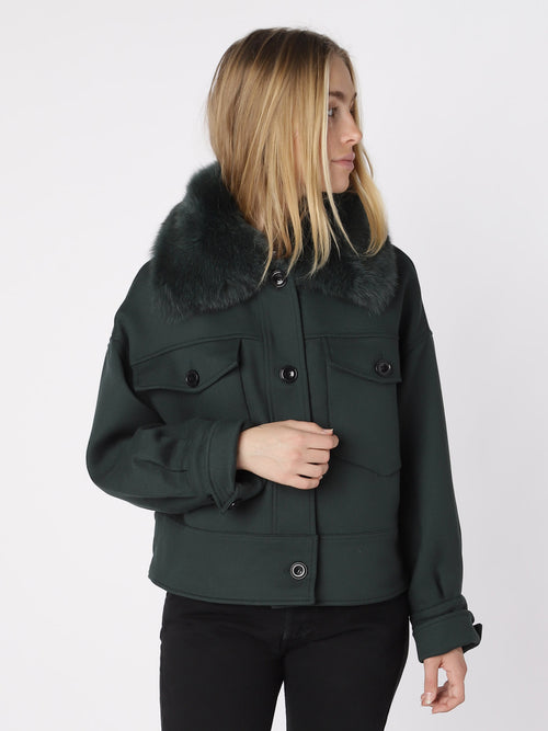 A model wearing a dark green cropped jacket with a faux fur collar, showcasing a stylish and modern look by MEOTINE.